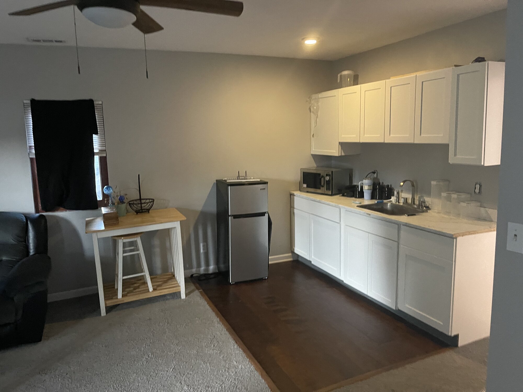 Kitchen with white cabinets, fridge, and microwave